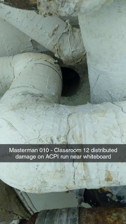 Damaged asbestos pipe insulation located in a classroom by the whiteboard.